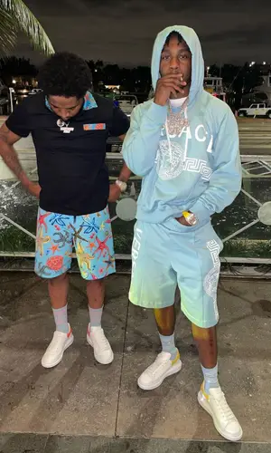 Lil Tjay wearing Versace shorts