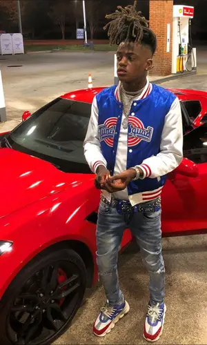 JayDaYoungan wearing Versace sneakers