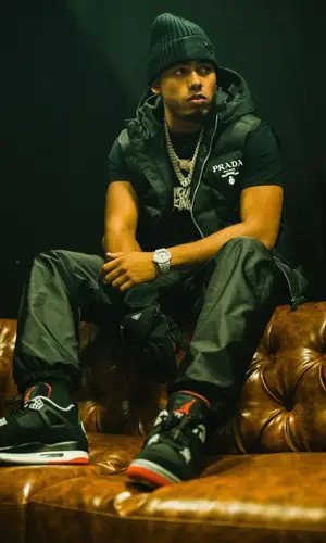 Myke Towers wearing Prada trousers