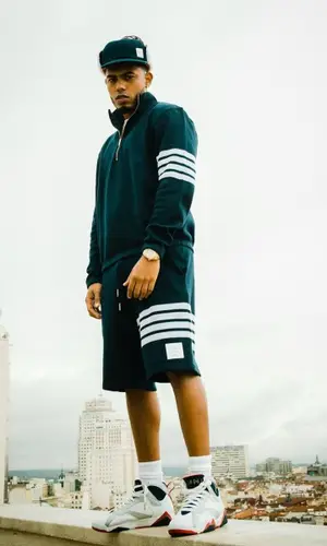 Myke Towers wearing Thom Browne sweater