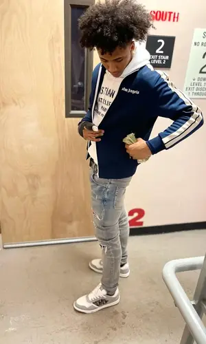 Mikey wearing Palm Angels jacket