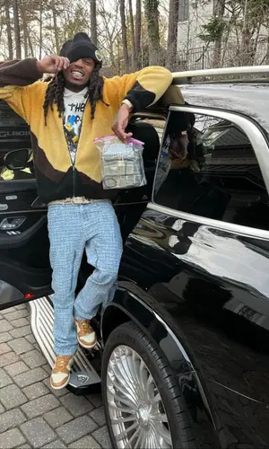 Quavo wearing Global Currency cap