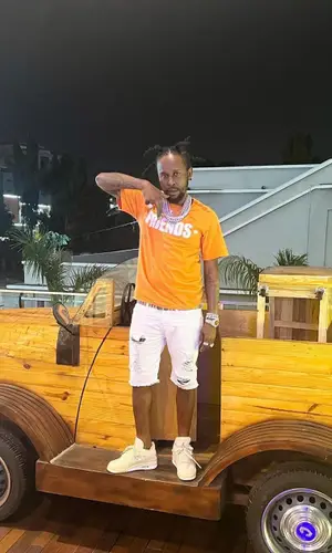 Popcaan wearing Burberry belt