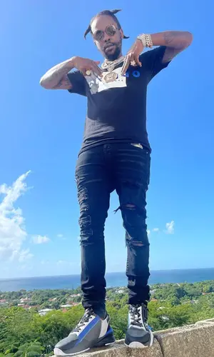 Popcaan wearing Amiri jeans
