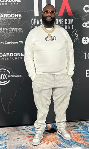 Rick Ross’ Outfit in Dior Sweatshirt, Nike Sneakers & Kenny Scharf (2022)