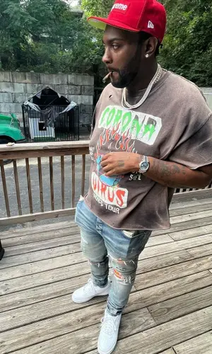 Peezy wearing Supreme cap