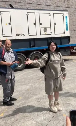 Billie Eilish’s Outfit in Fear of God Hoodie & Moon Boot Boots (2022)