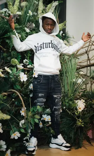 Bouba Savage’s Outfit in Amiri Jeans, Dior Sneakers & Nodisturbance Cap (2022)