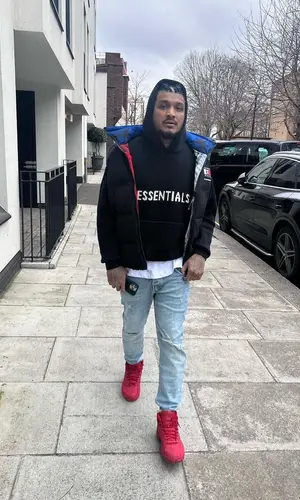 Divine wearing Tommy Hilfiger jacket