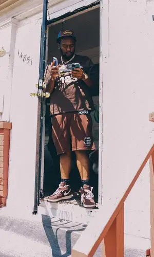 Peezy wearing Supreme cap