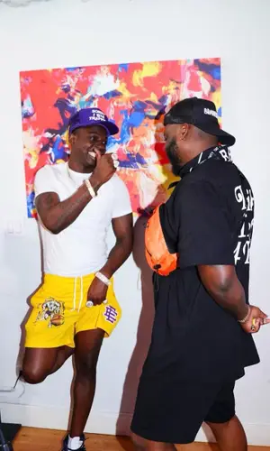Bobby Shmurda wearing Sorry I Was Trapping cap