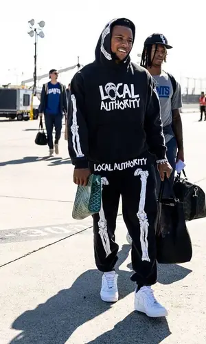 Saquon Barkley’s Outfit in Local Authority LA Hoodie, Nike Sneakers & Goyard Bag (2022)