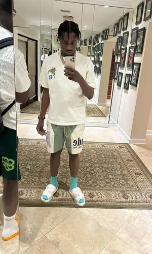 Lil Tjay wearing Rhude shorts