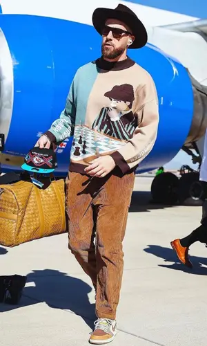 Travis Kelce’s Outfit in KidSuper Sweater, Bottega Veneta Bag & New Era Cap (2023)