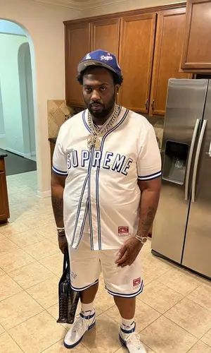 Peezy wearing Goyard bag
