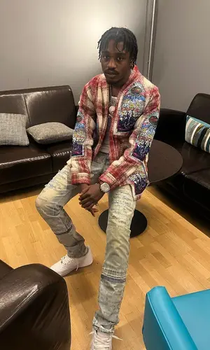 Lil Tjay wearing Who Decides War sweater