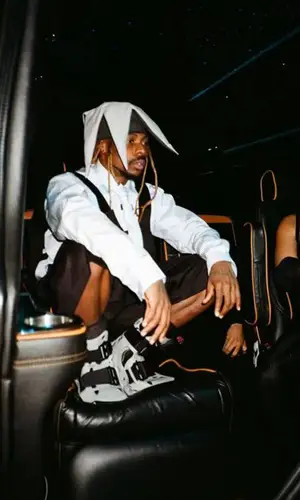 Asake wearing Comme Des Garcons shorts