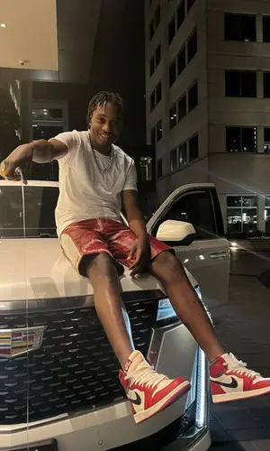 Lil Tjay wearing Who Decides War shorts
