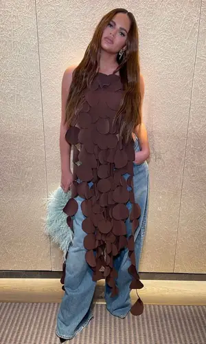 Chrissy Teigen’s Outfit in A.W.A.K.E. Mode Top, Agolde Jeans & Givenchy Bag (2023)