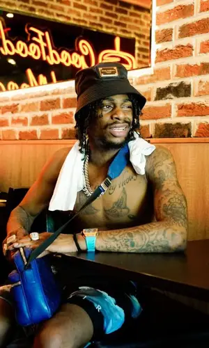 Russ Millions wearing Louis Vuitton bag