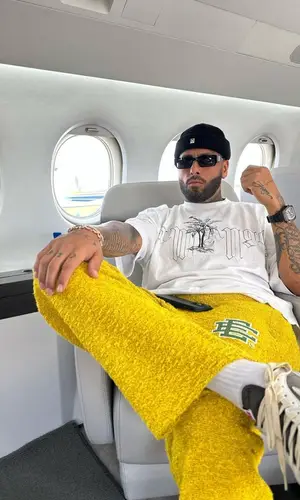 Nicky Jam’s Outfit in Palm Angels T-Shirt, Eric Emanuel Pants & A BETTER FEELING Eyewear (2023)