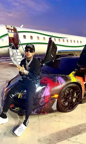 6ix9ine’s Outfit in Palm Angels Sweatshirt, Saint Laurent Pants & Versace Eyewear (2023)