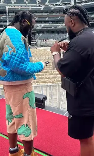 Burna Boy wearing Who Decides War shorts