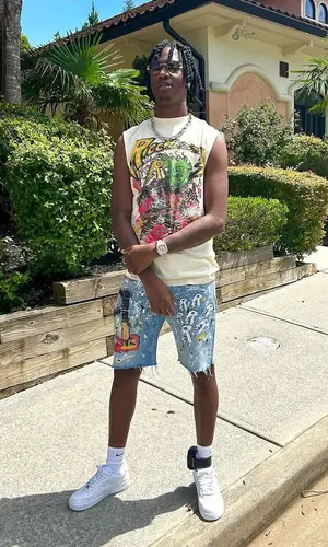 Yung Mal wearing Ricchezza Forever shorts
