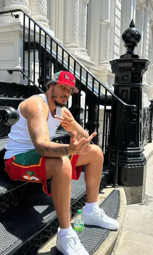 AJ Tracey wearing Mitchell & Ness shorts