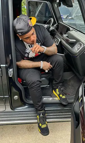 Finesse2tymes wearing New Era cap