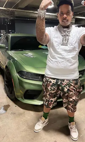 Finesse2tymes wearing Purple Brand shorts