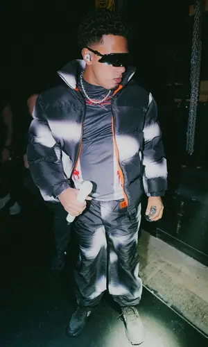 Myke Towers wearing Heron Preston jersey