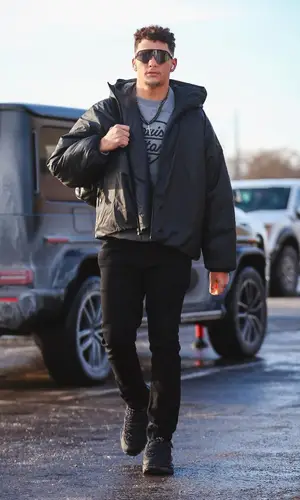 Patrick Mahomes II’s Outfit in Nigo Sweatshirt, Louis Vuitton Backpack & Oakley Eyewear (2024)