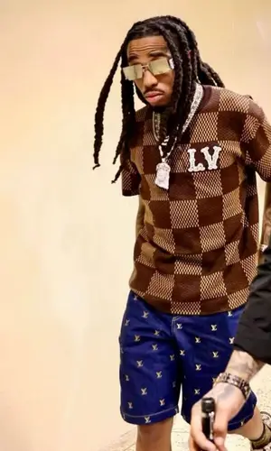 Quavo wearing Louis Vuitton shorts