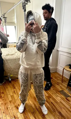Stunna Gambino’s Outfit in Denim Tears Hoodie, Vertabrae Hat & Saint Michael (2024)