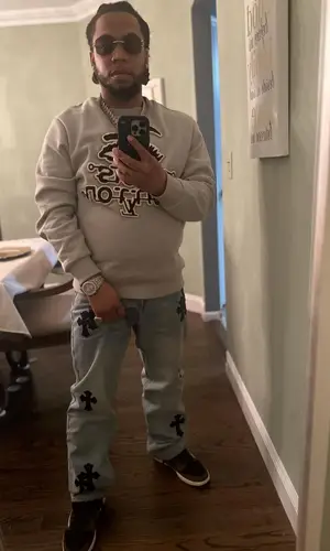 Don Q’s Outfit in Louis Vuitton Sweatshirt, Chrome Hearts Jeans & Travis Scott Merch Sneakers (2024)