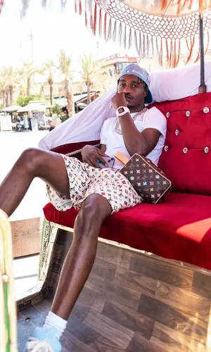 Lil Tjay wearing Louis Vuitton bag