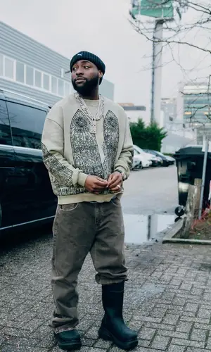 Davido’s Outfit in Who Decides War Sweater, Crocs Boots & Puma Hat (2024)