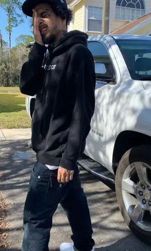 Wifisfuneral wearing New Era cap