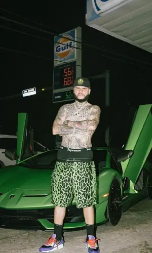 Farruko wearing Versace shorts