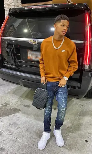 YK Osiris wearing Louis Vuitton bag