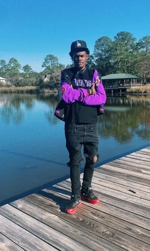 Ugly God wearing Mitchell & Ness jacket