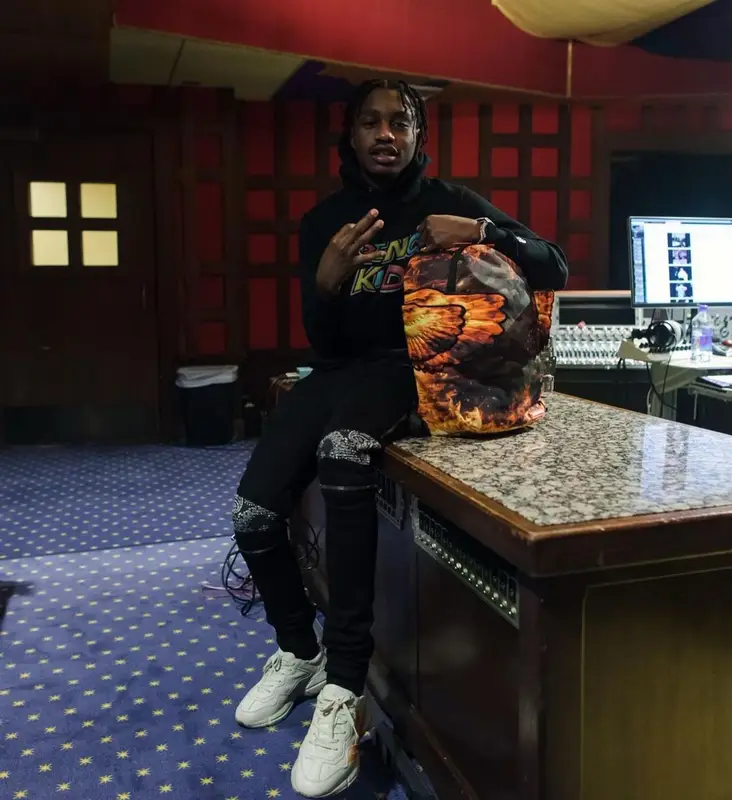 Lil Tjay outfit in Amiri, Gucci, and Sprayground, 2021