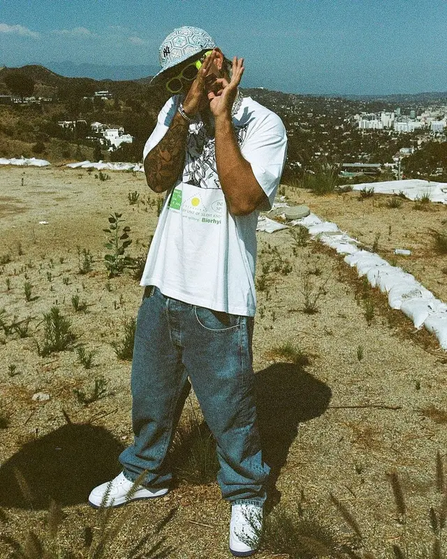 Feid outfit in Versace, New Era, and Kith, 2021