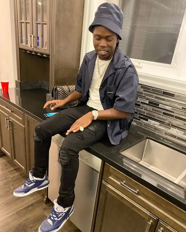 Burna Bandz outfit in Amiri, Jordan, and Prada, 2022