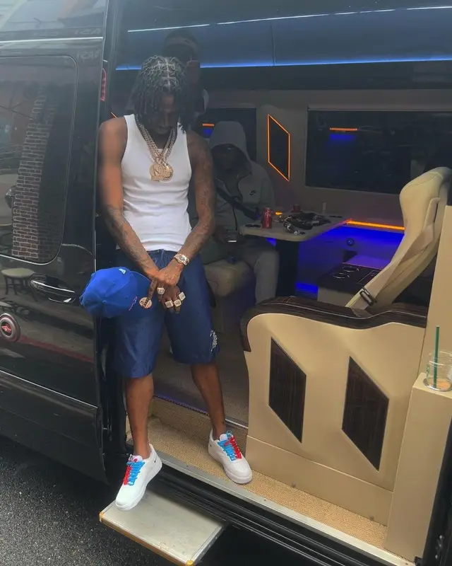 Russ Millions outfit in Louis Vuitton, Nike, and New Era, 2023