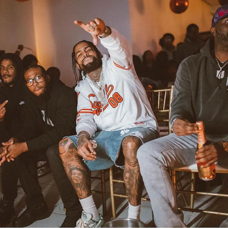 Dave East outfit in Supreme, Denim Tears, and Mitchell & Ness, 2023