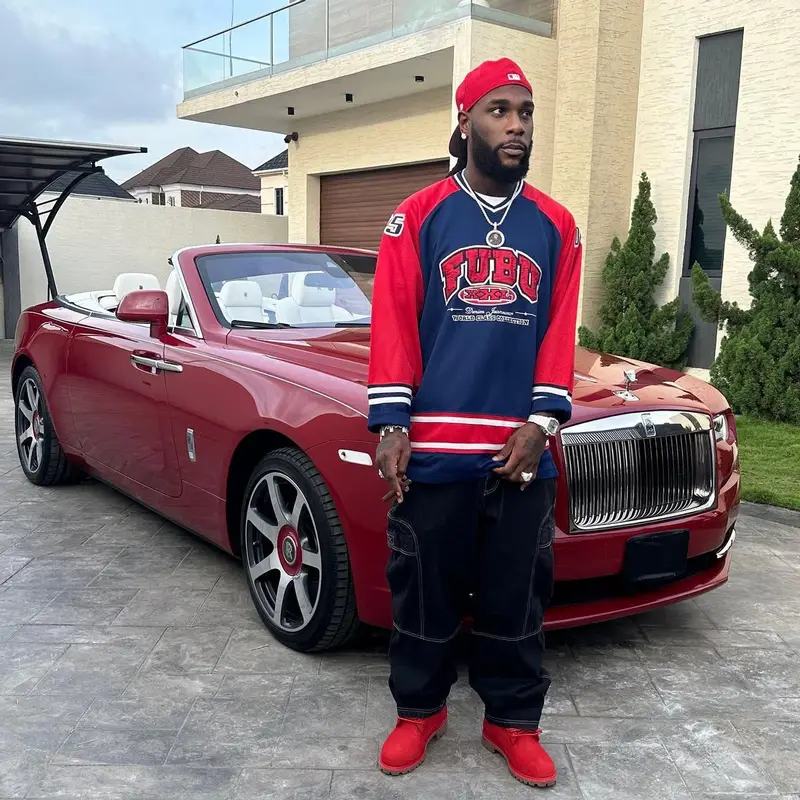 Burna Boy outfit in Fubu, Timberland, and New Era, 2023