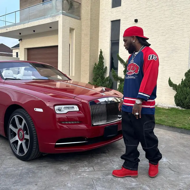 Burna Boy outfit in Fubu, Timberland, and New Era, 2023