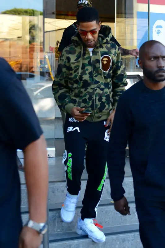 Kid Cudi outfit in Bape, Ray-Ban, and Champion, 2018